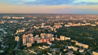 Chisinau 'nun günbatımında hava aracı görüntüsü. Birden fazla binanın manzarası, yollar, yemyeşil alanlar. Moldova