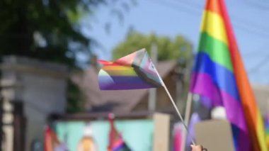 Lots of people at the gay pride parade in the center of Chisinau, Moldova. Multiple rainbow flags and posters. Slow motion