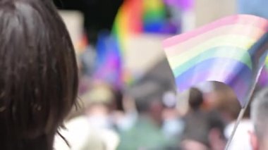 Lots of people at the gay pride parade in the center of Chisinau, Moldova. Multiple rainbow flags and posters. Slow motion