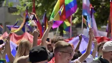CHISINAU, MOLDOVA - JUNE, 2022: Lots of people at the gay pride parade in the city center. Multiple rainbow flags and posters