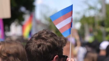 CHISINAU, MOLDOVA - JUNE, 2022: Lots of people at the gay pride parade in the city center. Multiple rainbow flags and posters. Slow motion