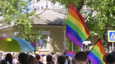 CHISINAU, MOLDOVA - JUNE, 2022: Lots of people at the gay pride parade in the city center. Multiple rainbow flags and posters. Slow motion