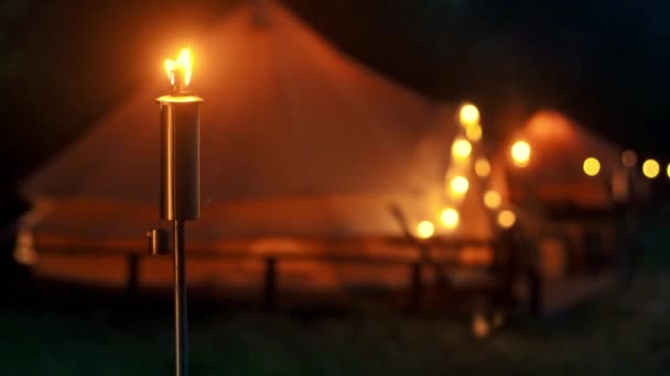Tents Burning Torches Lamps Wooden Chairs Glamping Forest Night — Vídeos de Stock