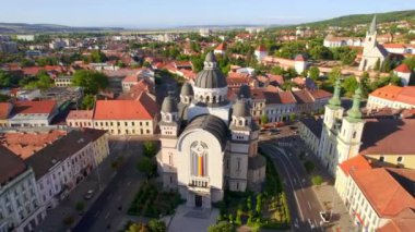 Aerial drone view of Ascension of the Lord Cathedral in the centre of Targu Mures, Romania. Targu Mures Fortress, old buildings, greenery, roads with cars