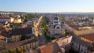 Aerial drone view of Ascension of the Lord Cathedral in the centre of Targu Mures, Romania. Old buildings, greenery, roads with cars