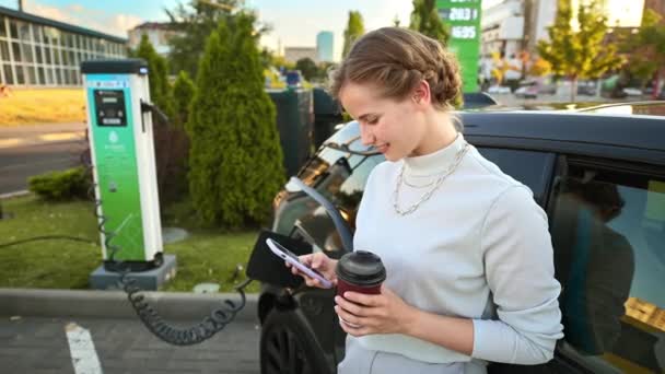 Young Blonde Woman Smartphone Coffee Car Charging Station Charging Electric — Stock videók