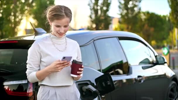 Young Blonde Woman Coffee Using Smartphone Car Charging Station Electric — Video