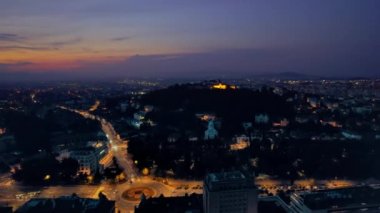 Aerial drone view of The Citadel in Brasov at night, Romania. Medieval fortress on the top of a hill. Buildings and roads with nightlights around