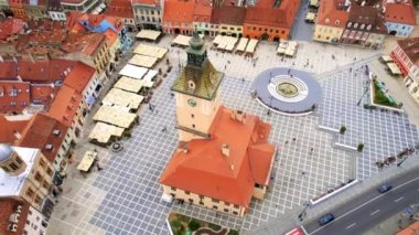 Aerial drone view of the main square in Brasov, Romania. Old city centre with museum of history, multiple buildings and people