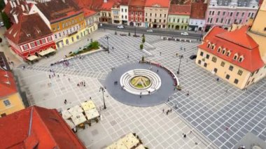 Aerial drone view of the main square in Brasov, Romania. Old city centre with museum of history, multiple buildings and people