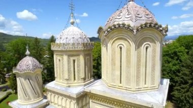 Aerial drone view of the Curtea de Arges Monastery in Romania. Multiple people in front of it, gardens around
