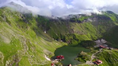 Aerial drone view of nature in Romania. Transfagarasan route in Carpathian mountains, Balea Lake resort and rocky slopes covered with greenery