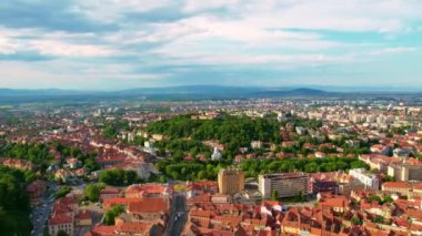 Aerial drone timelapse view of The Citadel in Brasov, Romania. Medieval fortress on the top of a hill. Buildings and green trees around