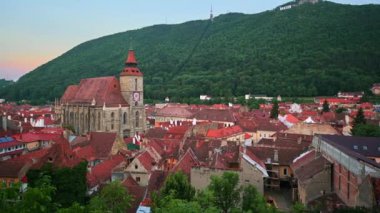 Romanya 'nın eski Brasov merkez manzarası. Siyah Kilise, eski apartmanlar, arka planda yeşil tepe.