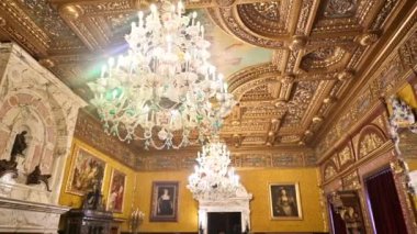 Peles Castle interior in Romania. A room with a classic design, golden details and chandeliers