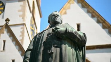 Monument of Bishop Georg Daniel Teutsch with Sibiu Lutheran Cathedral on the background in Romania