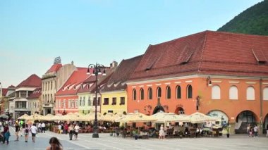 BRASOV, ROMANIA - JULY, 2022: View of the old city centre. Council Square with walking people, restaurants and old buildings