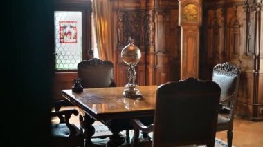 SINAIA, ROMANIA - JULY, 2022: Peles Castle interior in Romania. A room with a classic design and a table with a statuette