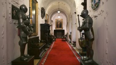 SINAIA, ROMANIA - JULY, 2022: Peles Castle interior in Romania. A room with a statues of knights and paintings, classic design