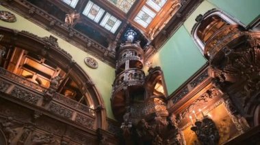 SINAIA, ROMANIA - JULY, 2022: Peles Castle interior in Romania. A room with a classic design, ceiling with stained glass window and multiple wooden details