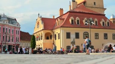 BRASOV, ROMANIA - JULY, 2022: View of the old city centre. Council Square with County Museum of History and walking people, restaurants and old buildings