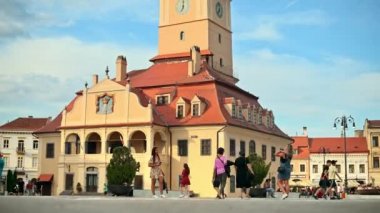 BRASOV, ROMANIA - JULY, 2022: View of the old city centre. Council Square with County Museum of History and walking people, restaurants and old buildings