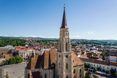 Aerial drone view of Saint Michael Church in Cluj, Romania. Cityscape, main bell tower, central square, old buildings, cars