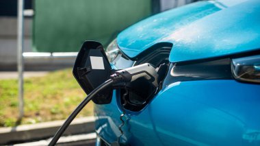 Close view of a charger plugged into an electric car at a charging station