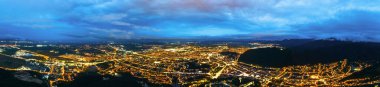 Aerial drone view of Brasov at night, Romania. Multiple buildings and roads with nightlights