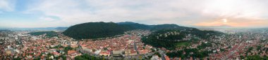 Aerial drone panoramic view of Brasov, Romania. Old city centre with old buildings, hills covered with greenery