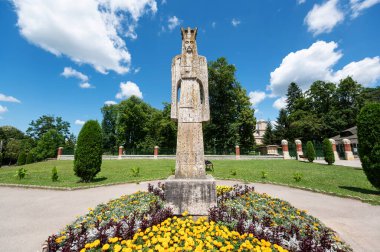 Curtea de Arges Monastery in Romania. Gardens with greenery and Neagoe Basarab monument