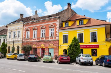 SIBIU, ROMANIA - AUGUST, 2022: View of the Historic Centre of the town. Street with old buildings made in national style and parked cars