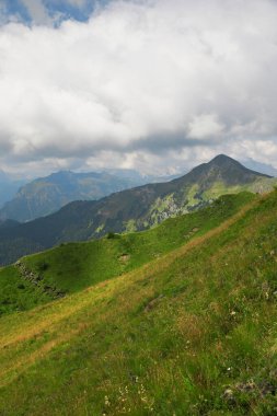 Dolomite Alps in Italy. Vertical view of mountains, valley and slopes covered with greenery and forest
