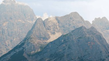 Dolomite Alps in Italy. View of a mountain rocky peaks, low clouds around
