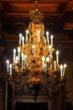 Peles Castle interior in Romania. Close view of a chandelier made in classic style