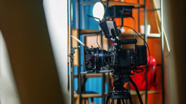 A professional camera on a tripod at a film set, interior on the background