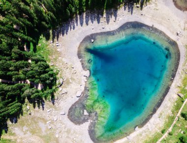 Dolomite Alps in Italy. Aerial drone view of the Lake of Carezza with blue water and forest around