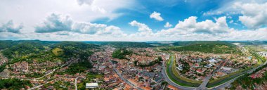 Aerial drone view of the Historic Centre of Sighisoara, Romania. Old buildings, narrow streets, greenery and hills