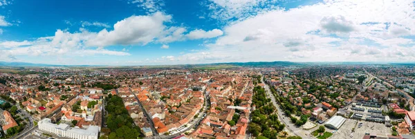 Aerial drone panoramic view of Sibiu centre, Romania. Cityscape, roads, old buildings, greenery