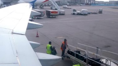 FRANKFURT, GERMANY - AĞUSTOS, 2022: Havaalanı personeli bavulları uçağa yüklüyor