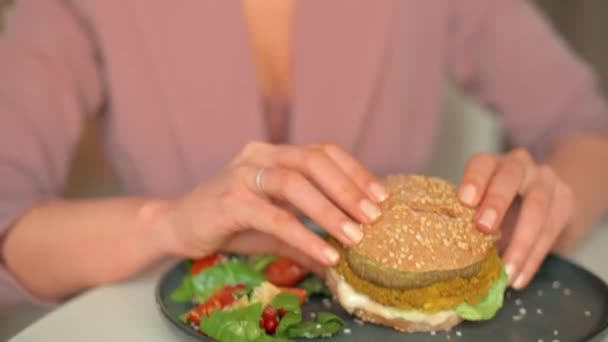 Kvinna Äter Vegan Burgare Med Tofu Ost Och Falafel — Stockvideo
