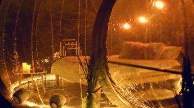 Transparent bubble tent at glamping at night, Interior with yellow illumination