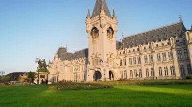 IASI, ROMANIA - AUGUST, 2022: Aerial drone view of the Palace of Culture in downtown at sunset. Square with Stephen the Great statue, people and greenery in front of it
