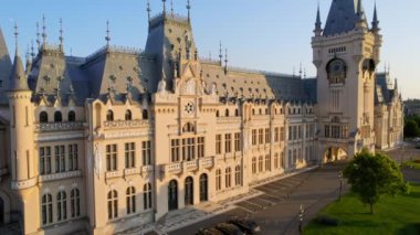 IASI, ROMANIA - AUGUST, 2022: Aerial drone view of the Palace of Culture in downtown at sunset. Square with Stephen the Great statue, people and greenery in front of it