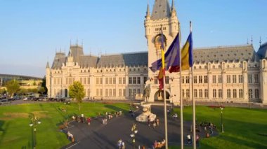 IASI, ROMANIA - AUGUST, 2022: Aerial drone view of the Palace of Culture in downtown at sunset. Square with Stephen the Great statue, people and greenery in front of it