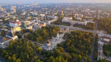 Chisinau 'nun gün batımında hava aracı görüntüsü. Central Park manzarası, Katedral, çan kulesi, Hükümet Binası ve Zafer Kemeri, bir sürü yeşillik, etrafta binalar. Moldova
