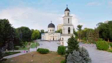 CHISINAU, MOLDOVA - 2022 AĞUSTOS: Gün batımında şehrin hava aracı görüntüsü. Central Park, Katedral, çan kulesi, bir sürü yeşillik ve yürüyen insanlar.