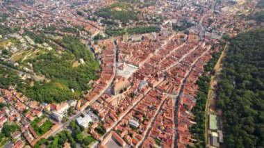 Aerial drone view of Brasov at sunset, Romania. Old city centre with buildings, hills and greenery