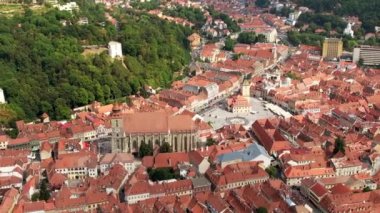 Aerial drone view of The Council Square in Brasov, Romania. Old city centre with County Museum of History, Black Church, buildings, people