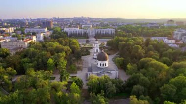 Chisinau 'nun gün batımında hava aracı görüntüsü. Central Park manzarası, Katedral, çan kulesi, Hükümet Binası ve Zafer Kemeri, bir sürü yeşillik, etrafta binalar. Moldova